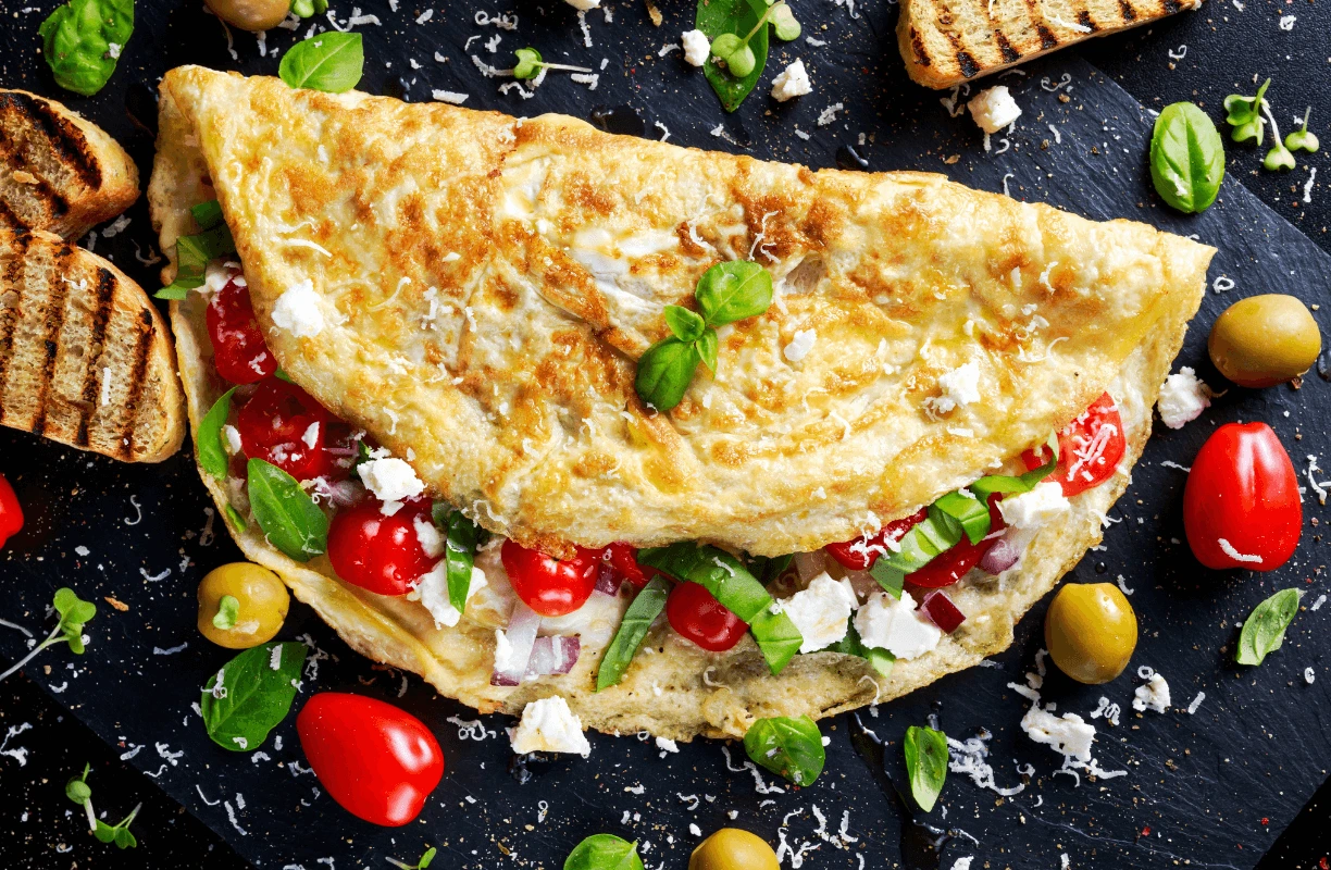 A beautifully folded omelette on a plate, filled with cheese and vegetables, and garnished with fresh parsley for a healthy and flavorful meal.