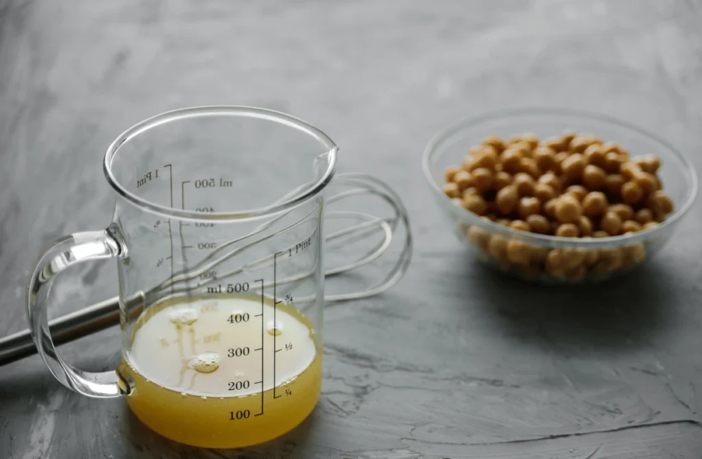 A measuring jug with chickpea flour batter and a bowl of chickpeas, perfect for making an egg-free omelette.