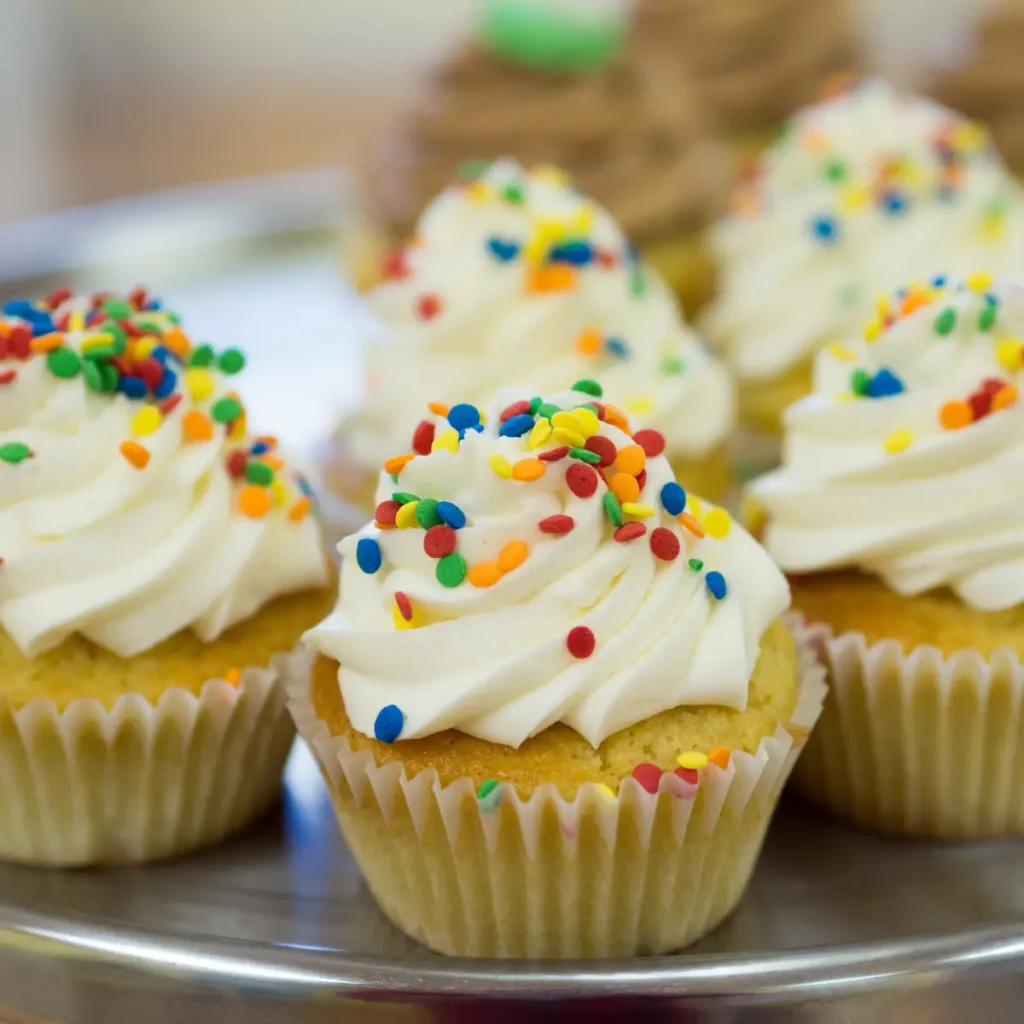 Assortment of gluten-free Easter desserts including carrot cake, lemon bars and coconut macaroons on spring-themed table